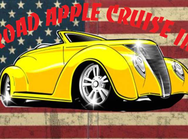Image of yellow classic car sitting in front of US flag