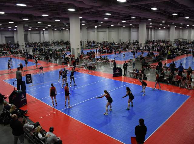 Mountain America Expo Center set up with volleyball courts, players on the court and spectators watching