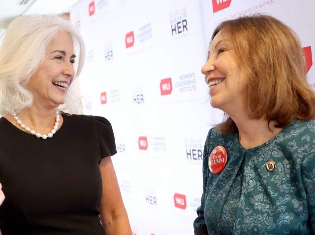Two women speaking together, background says U Women Leadership Institute