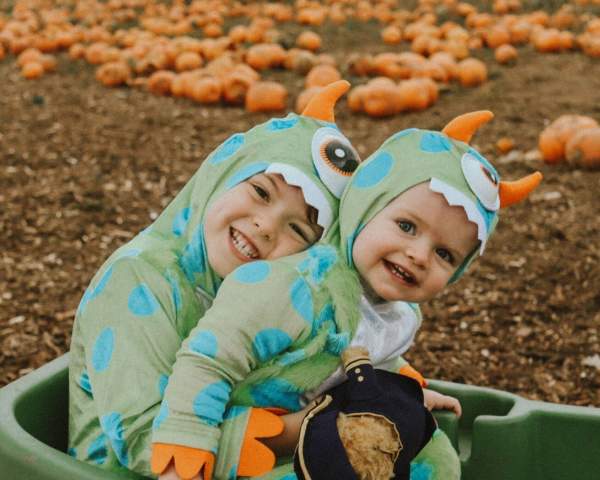 Children in fancy dress in pumpkin patch
