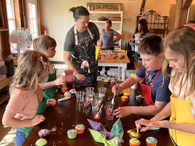 Julie with kids decorating cupcakes