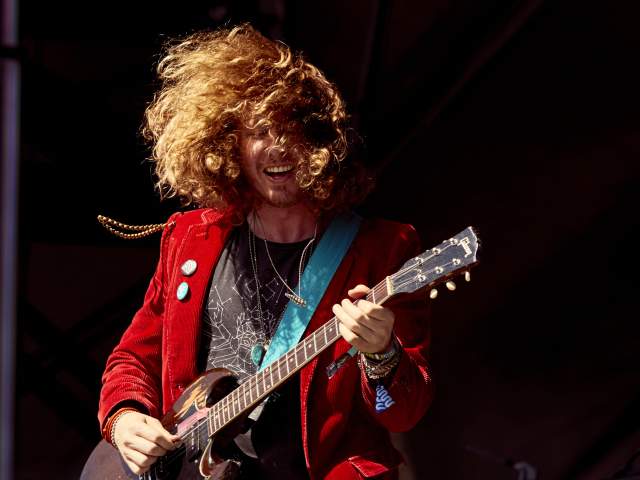 Ben Kweller playing guitar at ACL Fest in red blazer with buttons