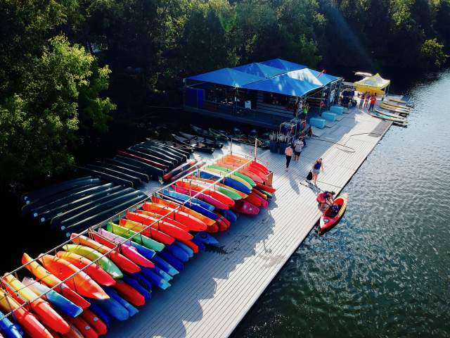 Aerial photo of the colorful kayaks and paddle boards at the Rowing Dock rental dock along the shore of Lady Bird Lake