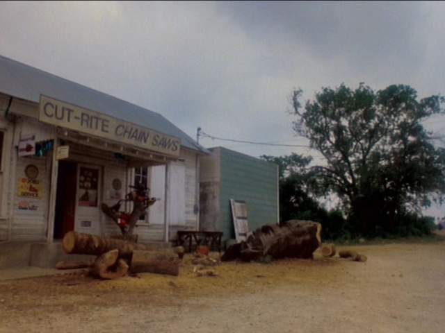 Texas Chainsaw Massacre 2 screengrab, showing the exterior of an old building with a sign reading Cut Rite Chainsaws