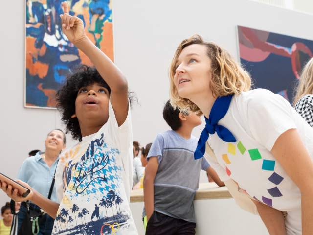 Boy pointing up at ceiling to a Blanton Museum of Art employee.