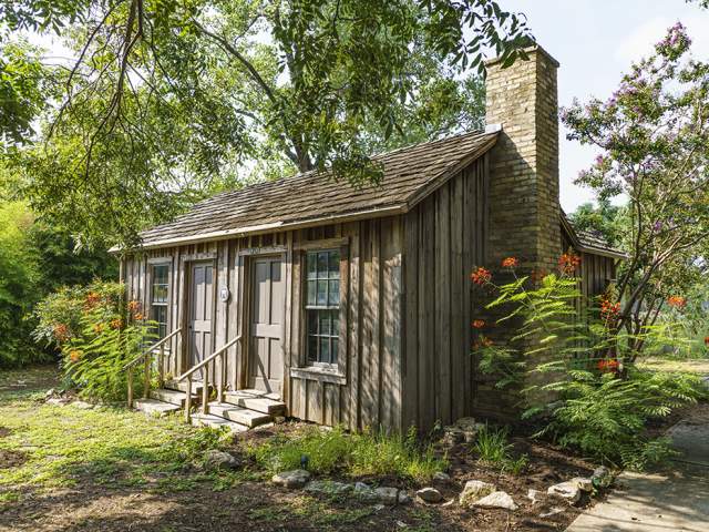 Historic Haskell House with blooming flowers around the exterior