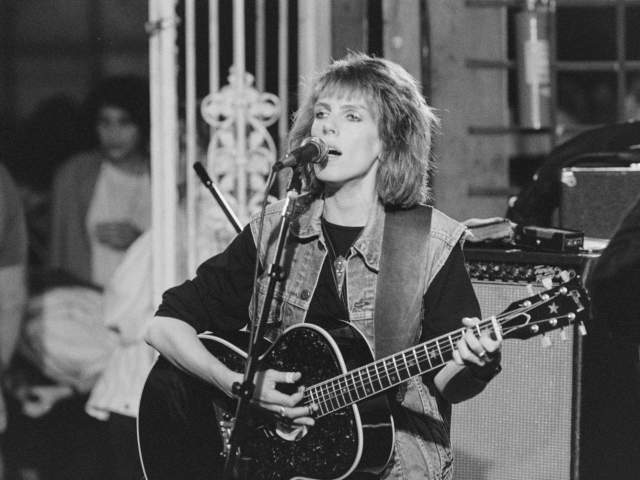 Black and white photo of Lucinda Williams performing with guitar at Black Cat Lounge
