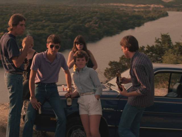 Blood Simple screengrab showing a group of young people leaning up against a car on top of Mount Bonnell