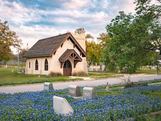 Chapel at Oakwood Cemetery behind a field of bluebonnets.