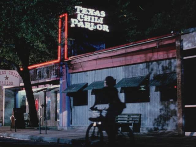 Grindhouse screengrab showing the exterior of a bar with a neon sign reading Texas Chili Parlor