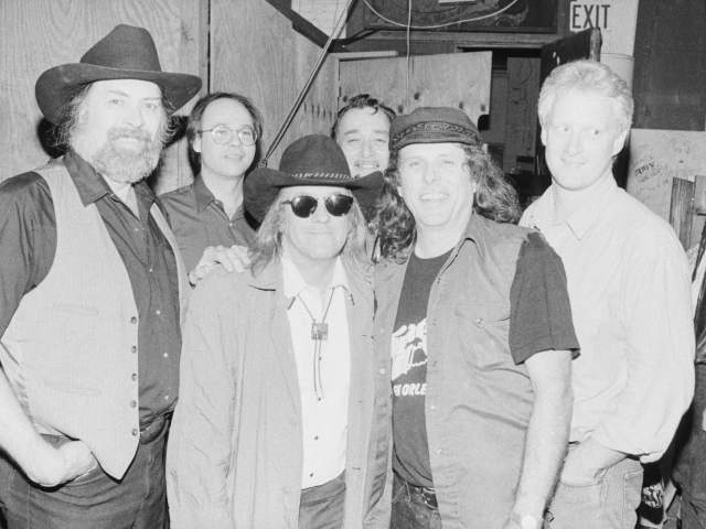 Black and white photo of members of the Texas Tornados smile at camera