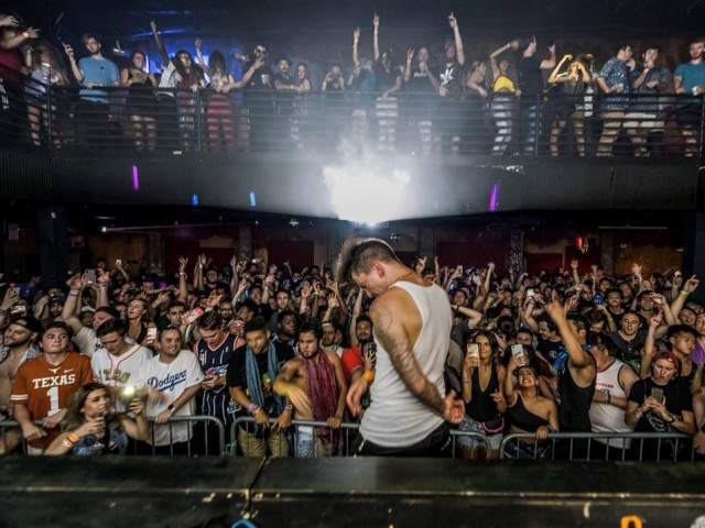 Artist on stage at Vulcan Gas Company in front of crowd on two levels