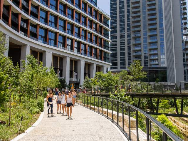 People walking along the Confluence at Waterloo Greenway near 1 Hotel Austin.