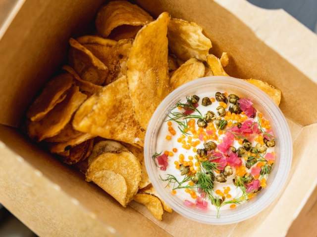 Smoked Salmon Sour Cream Dip and chips in takeout container from Drop Kick in Austin TExas