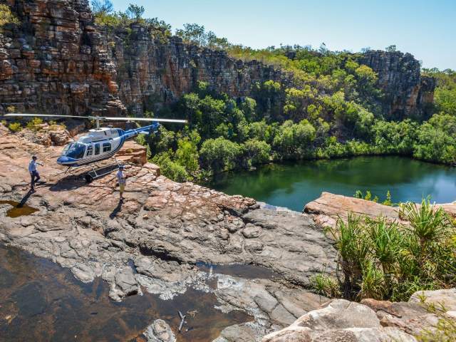 A HeliSpirit pilot and passenger explore a remote Kimberley waterfall by foot after a helicopter landing