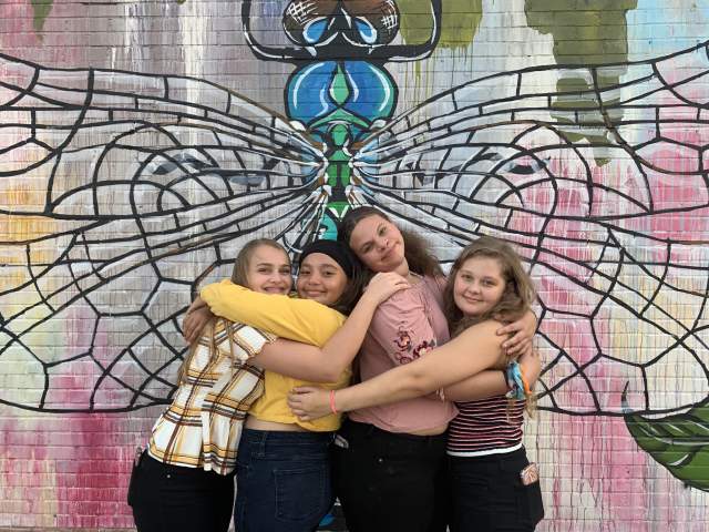 Teens posing in front of Dragonfly wall mural in Beaumont