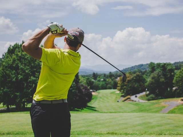 Man taking a golf swing at a golf course in Beaumont, TX