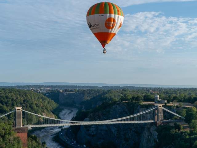 A green and orange striped balloon over the Clifton Suspension Bridge
