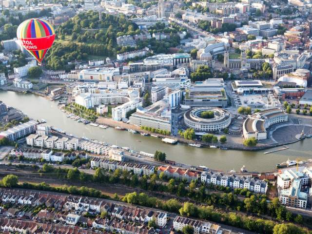 An aerial view of hot air balloons flying over Bristol Harbourside