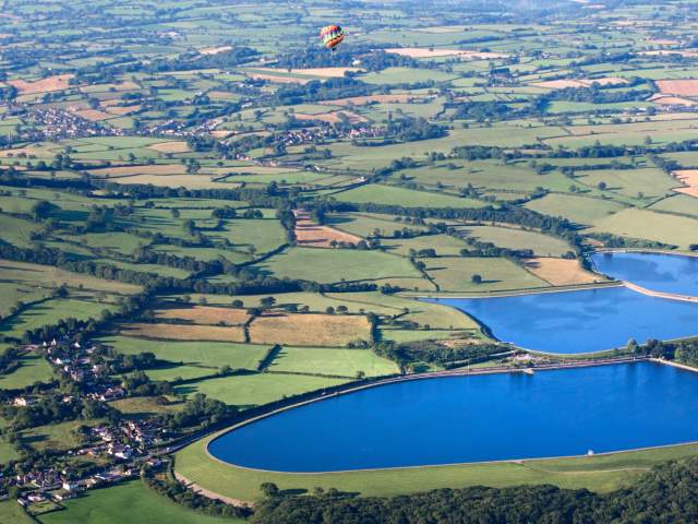 A balloon from the Bristol International Balloon Fiesta flying over the North Somerset countryside near Bristol - credit Paul Box