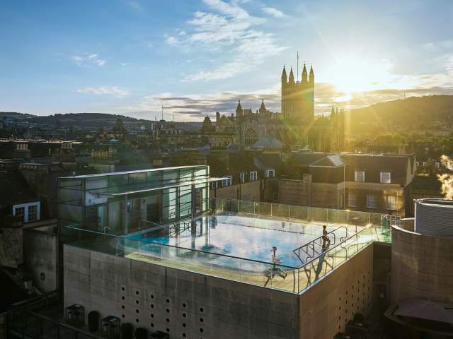 An aerial view of the rooftop pool at the Thermae Bath Spa in central Bath, with Bath's skyline in the background