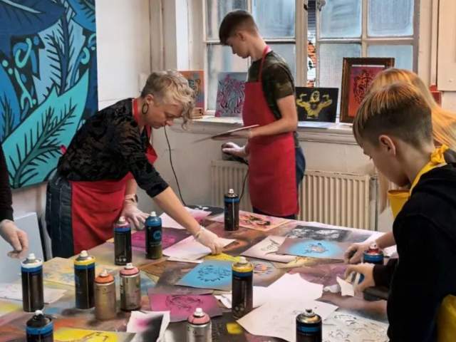 Group spray painting a canvas - credit Yuup / Graft