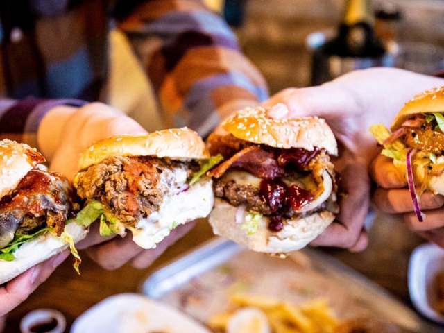 People holding four mini burger slides from Burger Theory