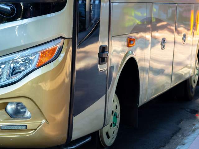 Gold coach parked by the side of the road