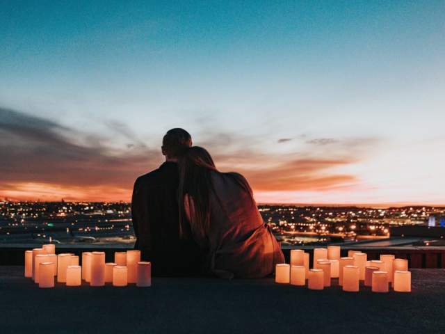 A couple surrounded by cangled watching the sunset - Credit Visit West