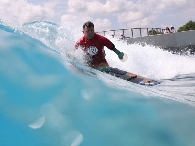 A surfer taking part in adaptive surfing at The Wave inland surfing lake near Bristol - credit The Wave