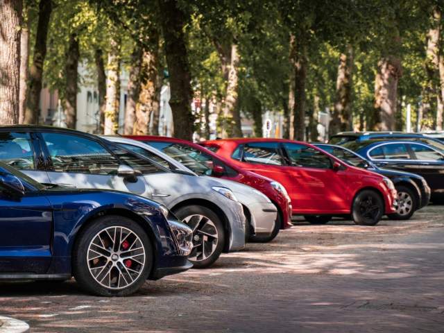 A row of cars parked underneath trees - Credit Michael Fousert