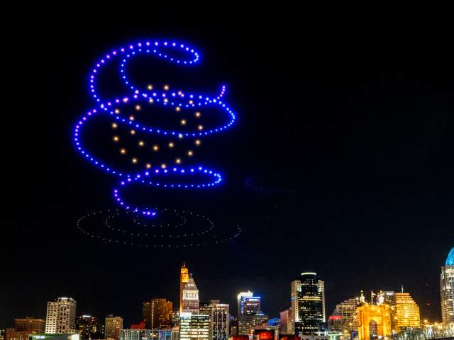 A spiral of lights floats above the river.