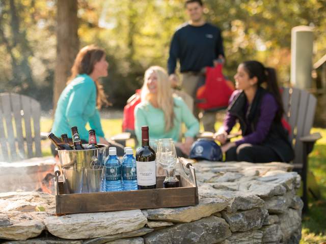 People sitting outside in Adirondack chairs with beer, wine spirits at the Allenberry Hotel in Boiling Springs, PA