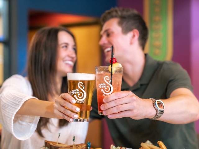 Couple doing cheers with beer at Isaac's Craft Kitchen & Brewery in Lemoyne