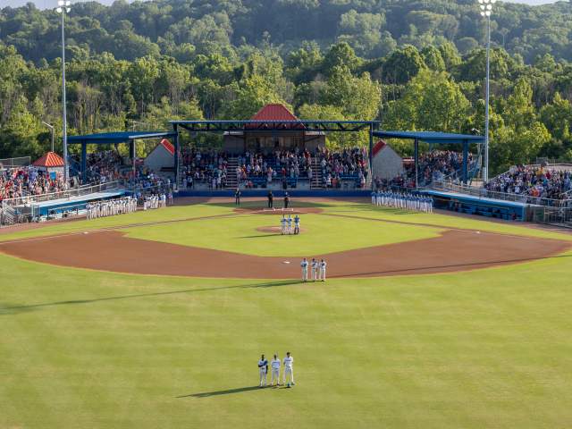 Players and fans standing for national anthem at baseball game