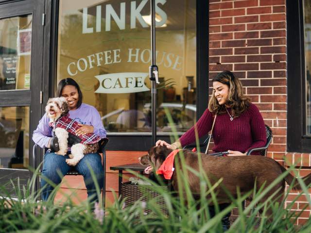 two women with their dogs and coffee