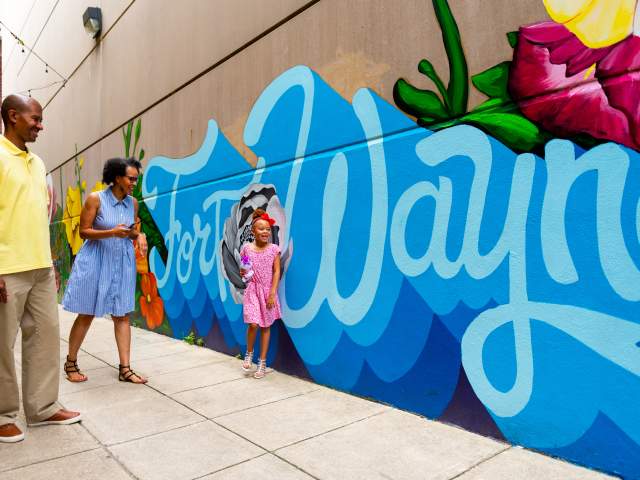 Family by a mural in downtown Fort Wayne