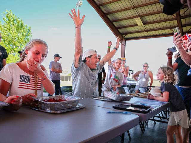 People competing in an eating contest at the 4th of July Grand County Fair.