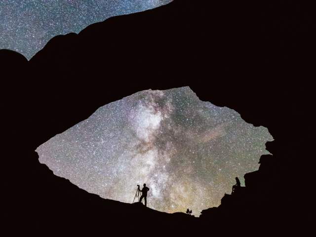 A silhouette of a photographer is captured from inside Mesa Arch in Canyonlands National Park (Island in the Sky district), located just outside Moab, Utah.