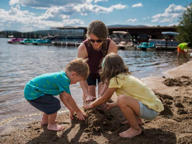 Family playing in sand on the beach in Grand Lake