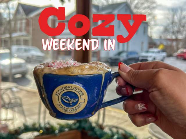 a hand holds a coffee mug overflowing with cold foam at Standing Stone Coffee Company in Huntingdon, PA