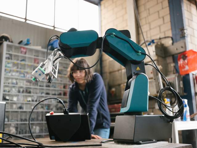 Person in a workshop, working on a robot