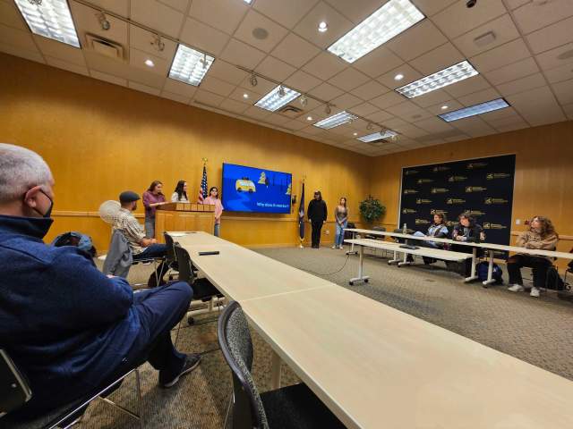 people sit in a boardroom listening to a presentation