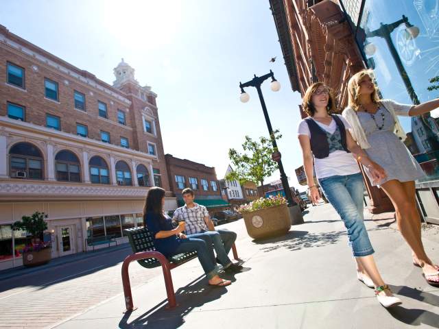 people walk about a downtown street