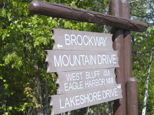 a wooden sign lists off directions