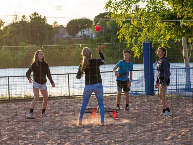 Kids play volleyball at Chutes and Ladders park in Houghton