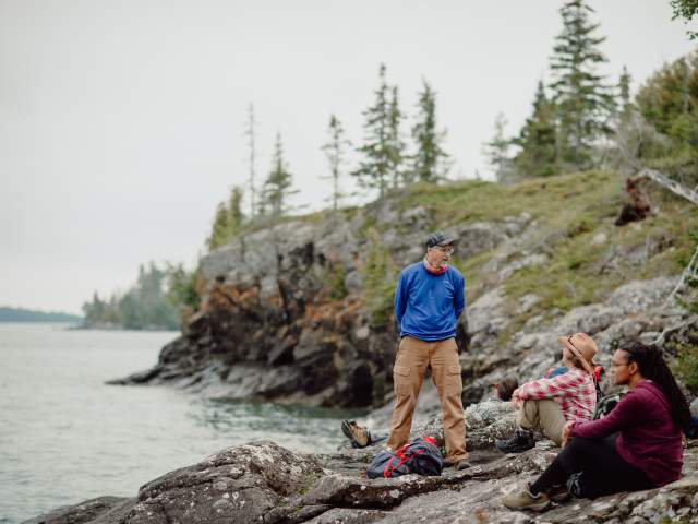 Group takes a break from hiking on the rugged shores of Isle Royale