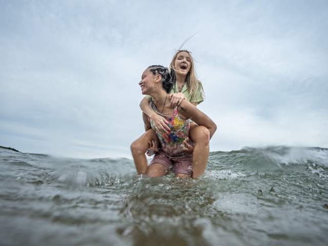 two laughing figures embrace in the water