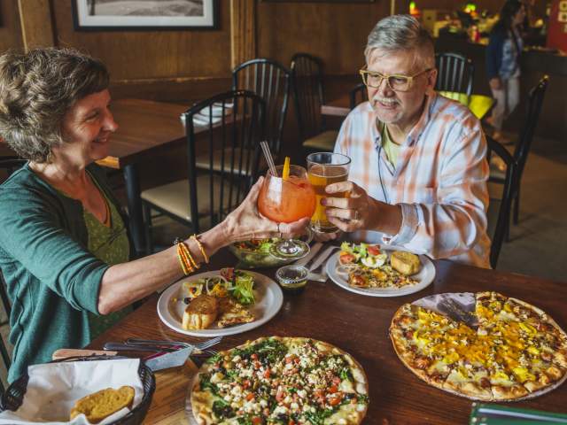 a couple cheers cocktails over pizzas