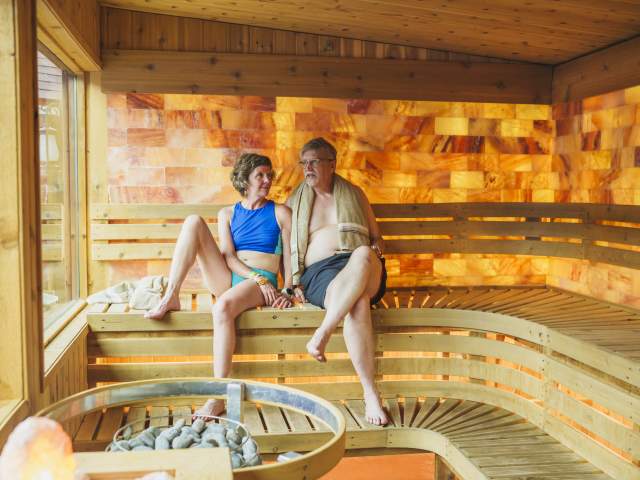 a couple sits inside a sauna